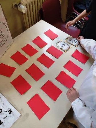 Mani di bambini che giocano con grandi tessere del Memory 