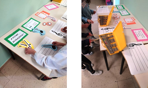 bambini che inventano ritmi con grandi note di carta e xilofoni.