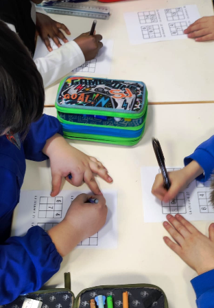 Bambini si esercitano con il "Quadrato magico" su fogli A4. Bambini si esercitano con il "Quadrato magico" su fogli A4.