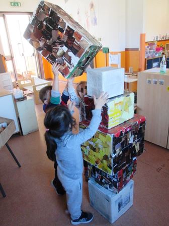 Bambini costruiscono una torre con gli scatoloni