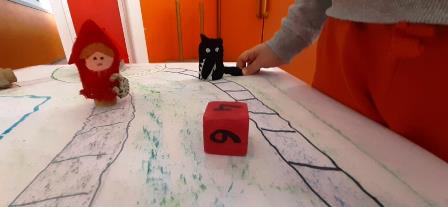 Bambino muove burattino sul tabellone del gioco di società Bambino muove burattino sul tabellone del gioco di società