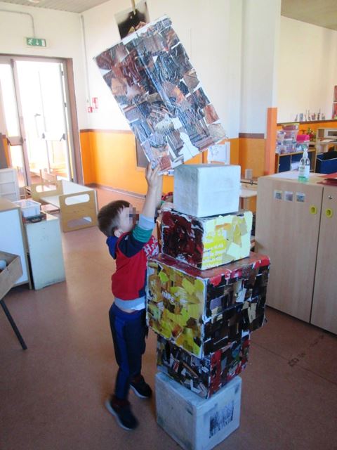 Bambino costruisce una torre con gli scatoloni