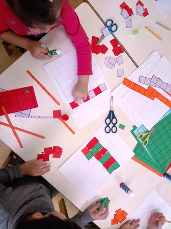 Bambini realizzano mosaici alternando tessere di carta colorata Bambini realizzano mosaici alternando tessere di carta colorata