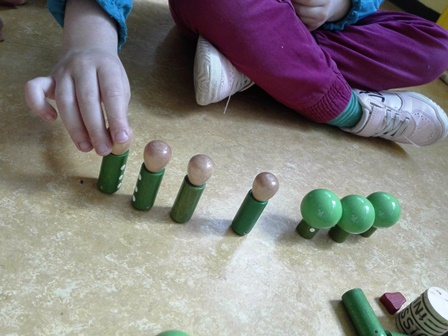 Bambino gioca con piccoli cilindri e sfere Bambino gioca con piccoli cilindri e sfere
