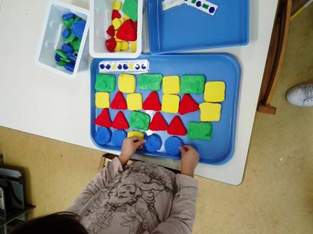 Bambina dispone forme geometriche costruite con la pasta di sale
