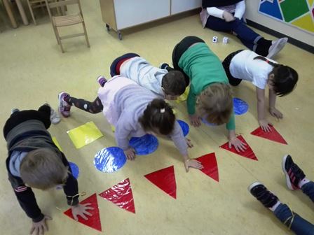 Bambini eseguono un gioco motorio con forme geometriche