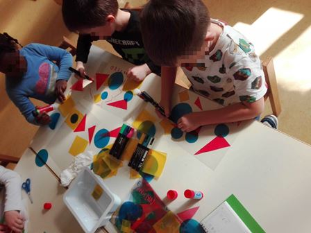Bambini realizzano un quadro con forme di acetato