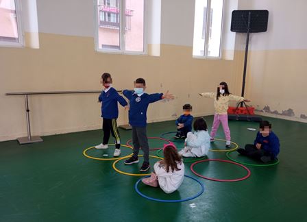 Bambini giocano in palestra con i cerchi