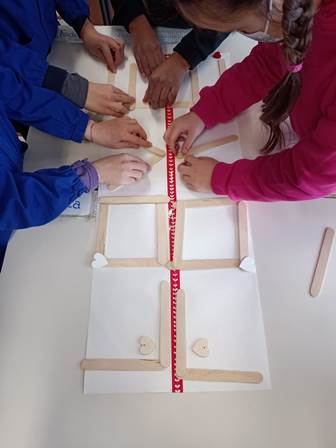 Bambini compongono la parola "love" con stecche di legno