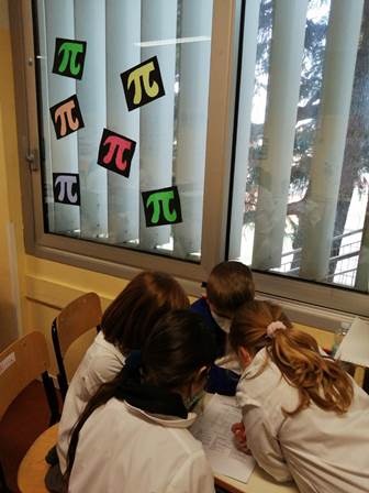 Gruppo di quattro bambini impegnato nella soluzione di quesiti matematici Gruppo di quattro bambini impegnato nella soluzione di quesiti matematici