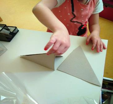 Bambina costruisce una tenda indiana per le bambole con pezzi di cartoncino Bambina costruisce una tenda indiana per le bambole con pezzi di cartoncino